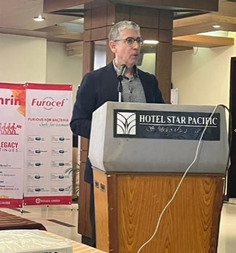 Dr. Paul Helpard speaking to local dentists at a podium with a sign that says, "Hotel Star Pacific"