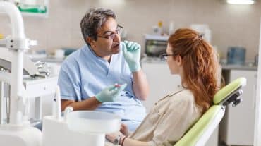 An orthodontists consults with a patient. Explore every orthodontic practice transition option, from traditional sales to a DSO to partnership models, before deciding what's right for your practice.