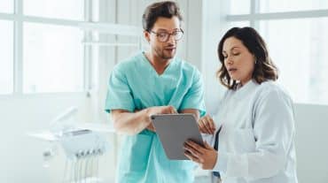 Two orthodontists work together. Compare orthodontic practice ownership structures, from independent practice to OSOs and DSOs, and what each means for your equity.