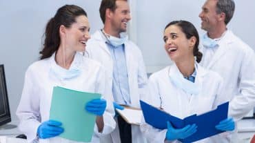 A team of orthodontists work together. Do employees keep their jobs after an orthodontic practice sale? What to negotiate for your team and how to share the news well.
