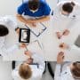 A group of orthodontists at a table together. Need help managing your orthodontic practice? Learn when to build your team, hire a consultant, or consider a partnership model.